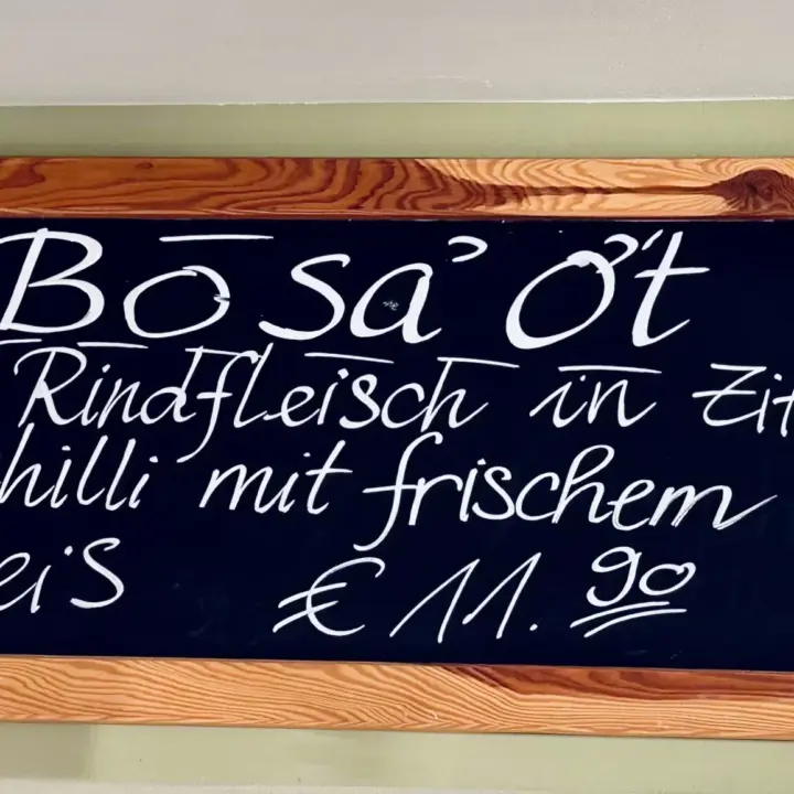 Schwarze Kreidetafel mit Tagesgericht „Bò Sá Ớt“: Rindfleisch in Zitronengras-Chili mit frischem Gemüse und Reis, Preis 11,90 €.